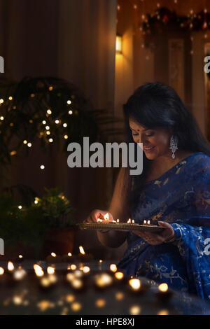 Frau, die Vermittlung von irdenen Lampen an diwali Stockfoto