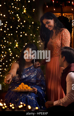 Frau mit ihrer Tochter und Schwiegersohn feiern Diwali Stockfoto