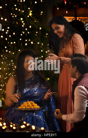 Frau mit ihrer Tochter und Schwiegersohn feiern Diwali Stockfoto