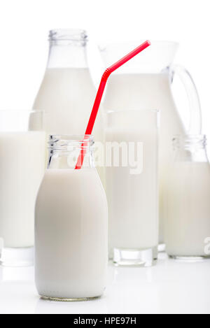 Milchflasche mit roten trinken Stroh und andere Milchgläser auf Hintergrund Stockfoto