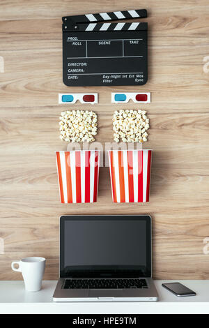 Laptop, Popcorn, 3D-Brille und Schindeln auf einem hölzernen Oberfläche, Kino und Entertainment-Konzept Stockfoto