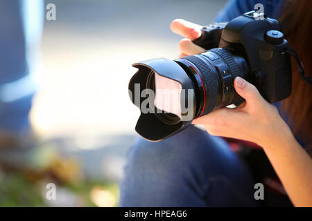 Eine junge Frau hält eine Vollformat-Kamera. Stockfoto