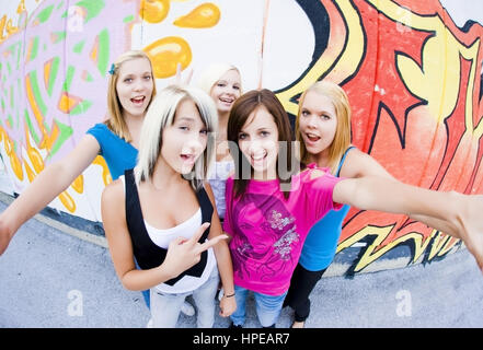 Model Release, Gruppe Jugendlicher näher Vor Graffitiwand - Gruppe von Mädchen vor der Graffitiwand Stockfoto