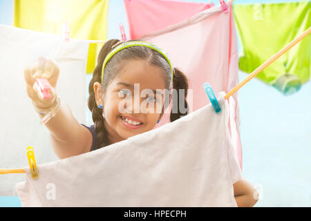 Junges Mädchen Tücher auf einer Wäscheleine trocknen Stockfoto