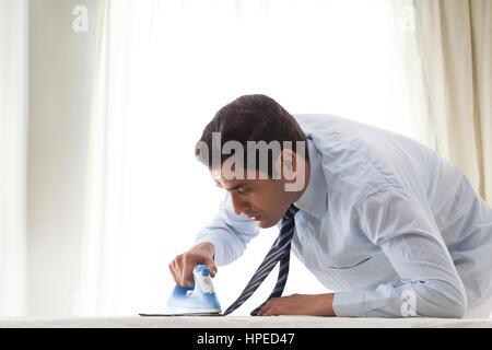 Geschäftsmann Bügeln Krawatte Stockfoto