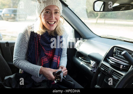 Frau in Auto fahrer Sitz in die Kamera schaut Stockfoto