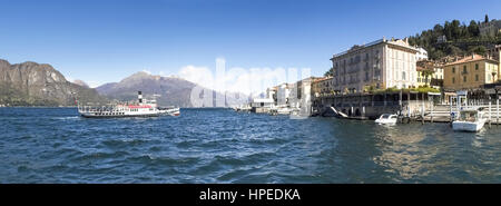 Bellagio der Comer See, Italien - 1. April 2015: Dock von Bellagio mit historischen Häusern des 19. Jahrhunderts. Ein PKW-Boot-Service auf dem See approachin Stockfoto