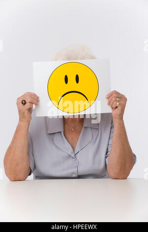 Model Release, Seniorin Mit Traurigem Smileygesicht - ältere Frau mit traurigen Smiley-Gesicht Stockfoto