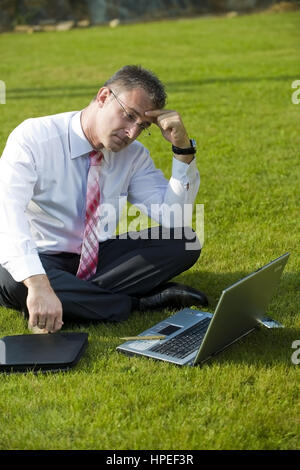 Model Release, Geschaeftsmann Sitzt Mit Laptop in der Wiese - Geschäftsmann in der Wiese sitzen und mit laptop Stockfoto