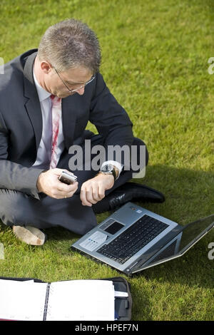 Model Release, Geschaeftsmann Sitzt Mit Laptop in der Wiese - Geschäftsmann in der Wiese sitzen und mit laptop Stockfoto