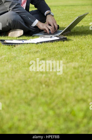 Model Release, Geschaeftsmann Sitzt Mit Laptop in der Wiese - Geschäftsmann in der Wiese sitzen und mit laptop Stockfoto