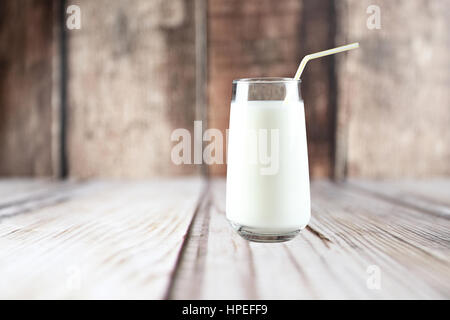 Glas Milch auf dem Tisch auf hölzernen Hintergrund mit selektiven Fokus Stockfoto