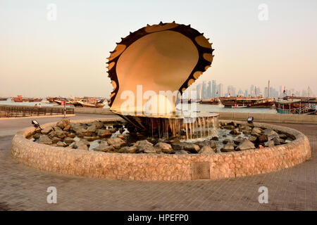 Doha, Katar - 2. November 2016. Perle-Denkmal in Doha, mit Menschen, Autos, Boote und Gebäuden im Hintergrund, im Morgengrauen Stockfoto