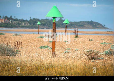 Shingle Street Suffolk, Blick im Sommer auf die Flut Pfosten entlang des Strandes in Shingle Street in der Nähe von Hollesley in Suffolk, Großbritannien verstreut. Stockfoto