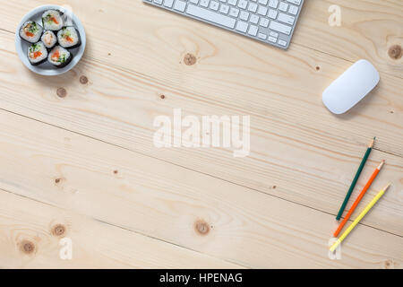 Bild von hellen Holztisch mit Geschäfts- und Hobby-Artikel und Sushi Set Computer Tastatur Farbstiften von oben Stockfoto