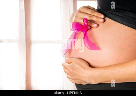 Mutter hält Rosa Schleife am Bauch Stockfoto