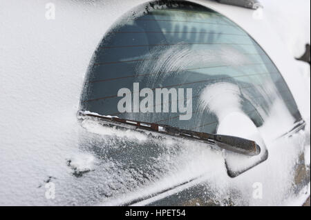 Der Wischer auf der Heckscheibe des Wagens nach der Fahrt auf einer verschneiten Straße. Stockfoto