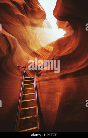 Schöne Aussicht auf erstaunliche Sandstein-Formationen mit einer Leiter, die gegen eine magische Lichtstrahl in berühmten Antelope Canyon in der Nähe von Page, Arizona, USA Stockfoto