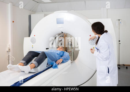 Reife Arzt Blick auf weibliche Patienten gehen durch CT-Untersuchung im Krankenhaus Stockfoto