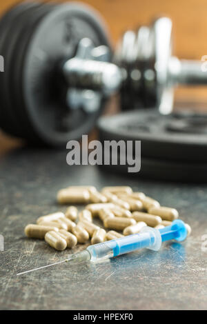 Doping im Sport. Spritze und Hantel. Stockfoto