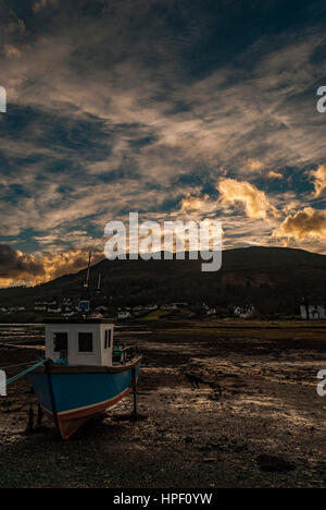 Boot im Vordergrund mit gelben Wolken über Loch Portree, Februar 2017, Blick von der Küste Bayfield, Portree, Isle Of Skye, Schottland. Stockfoto