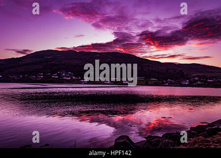 Reflexion der lila Himmel und rote Wolken über Loch Portree, Februar 2017, Blick von der Küste von "The Klumpen" Portree, Isle Of Skye, Schottland. Stockfoto