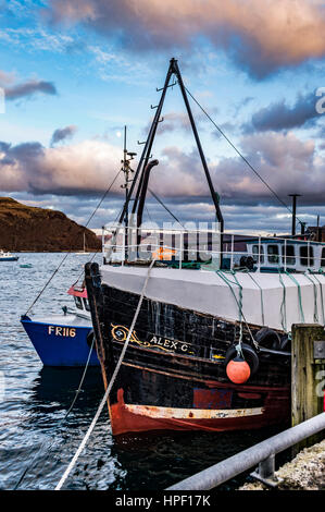 Angelboot/Fischerboot angedockt am Kai von Portree Hafen, Isle Of Skye Schottland gegen einen späten Nachmittag Himmel, mit Sound of Raasay im Hintergrund. Stockfoto