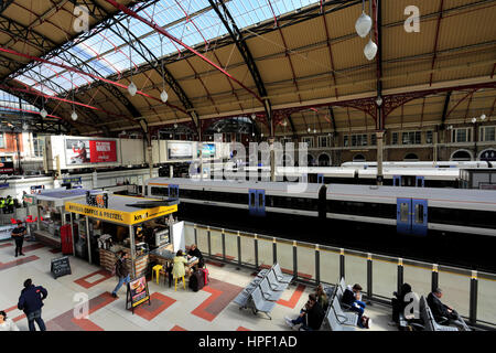 Menschen auf die Bahnhofshalle und Abreise Bretter; Innen Victoria Railway Station, London UK Stockfoto