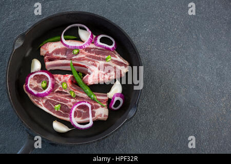 Messer hacken und gehackten Chilischoten und Zwiebeln in die Pfanne vor schwarzem Hintergrund Stockfoto