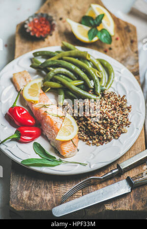 Gesunde Protein Reich Speiseteller. Ofen gebratenes Lachsfilet mit bunten Quinoa, Chilischote und pochierte grüne Bohnen auf rustikalem Holzbrett o Stockfoto