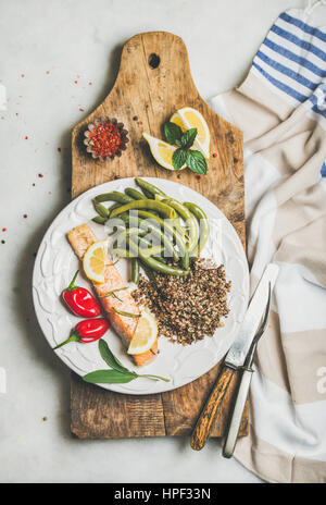 Gesunde Protein Reich Speiseteller. Ofen gebratenes Lachsfilet mit bunten Quinoa, Chilischote und pochierte grüne Bohnen auf rustikalem Holzbrett o Stockfoto