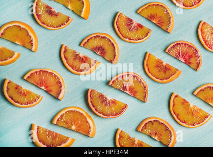 Natürliche Frucht Muster Konzept. Frische saftige Blutorange Scheiben über Leuchttisch blau bemalten Hintergrund, Draufsicht, horizontale Zusam in Reihen gelegt. Stockfoto
