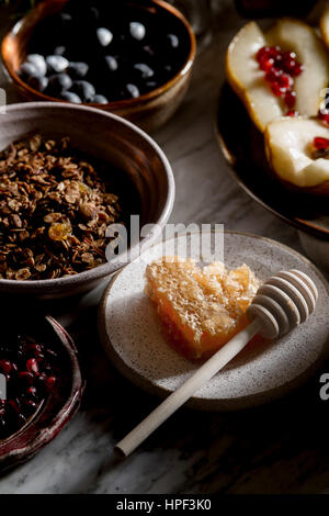 Hausgemachtes Müsli-Frühstück mit Honig und Früchten Stockfoto