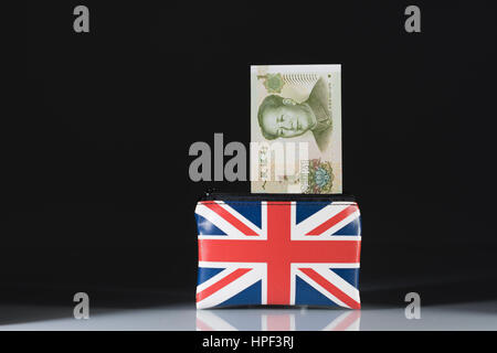 Union Jack Geldbeutel mit den chinesischen Yuan/Renminbi... vor einem dunklen Hintergrund. Metapher für Yuan-Pound Wechselkurs. China - Großbritannien Handels, Yuan Schwäche Stockfoto