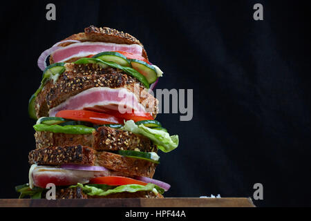 Frischen Thunfisch-Steak-Sandwich mit Salat, Tomaten und Gurken auf kernigen Handwerker Brot gestapelt Stockfoto