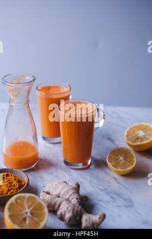 Brille von Orange, Zitrone und Karotten-Saft mit Kurkuma und Ingwer Stockfoto