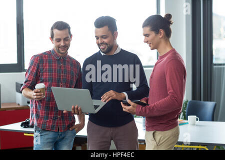 Geschäftsleute, die Diskussion über Laptop im Büro Stockfoto