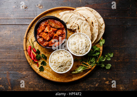 Chicken Tikka Masala-würzigen Curry-Fleisch-essen in Gusseisen-Topf mit Reis und Naan Brot auf hölzernen Hintergrund Stockfoto