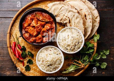 Chicken Tikka Masala scharfes Curry Fleisch Essen im Eisentopf mit Reis und Naan Brot hautnah Stockfoto