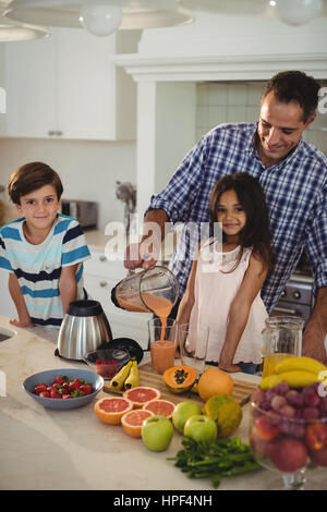 Vater Smoothie mit seinen Kindern in der Küche zu Hause vorbereiten Stockfoto