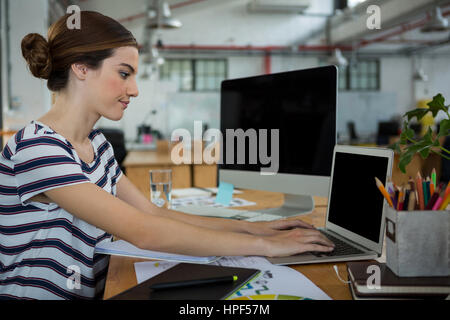 Grafik Designerin mit Laptop in Kreativbüro Stockfoto