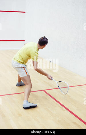 Rückansicht des Squashspieler in Aktion am Squash-Court. Squash verschwommenes Spieler in Aktion auf einem Squash Gericht wegen Bild. Squashspieler schlagen b Stockfoto