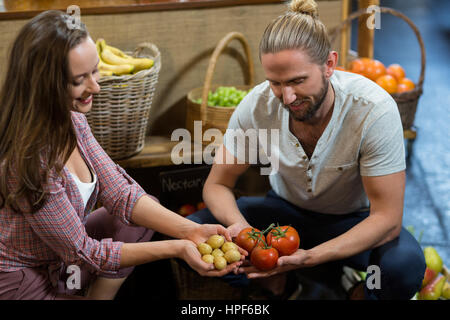 Mann und Frau Anbieter mit Kartoffeln und Tomaten im Supermarkt Stockfoto