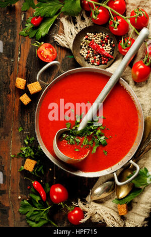 Hausgemachte Tomatensuppe auf Holztisch, Ansicht von oben Stockfoto