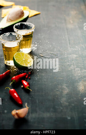 Tequila Shots und mexikanische Zutaten auf rustikalen Tisch Stockfoto