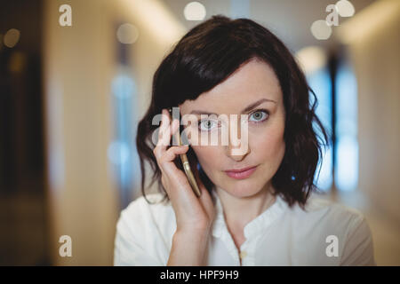 Porträt von weiblichen executive telefonieren mit Handy im Korridor des Büros Stockfoto