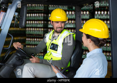 Lächelnde Fabrikarbeiter Interaktion mit einander in Fabrik Stockfoto