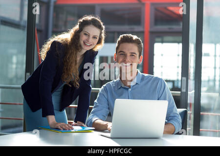 Porträt von Geschäftsleuten, die Diskussion über Laptop im Büro Stockfoto