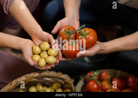 Nahaufnahme von Mann und Mann-Anbieter mit Tomaten und Kartoffeln im Supermarkt Stockfoto