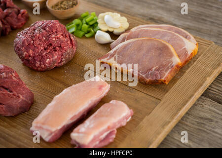 Sorten von Fleisch und Gewürzen auf Holztablett aus Holz Hintergrund Stockfoto